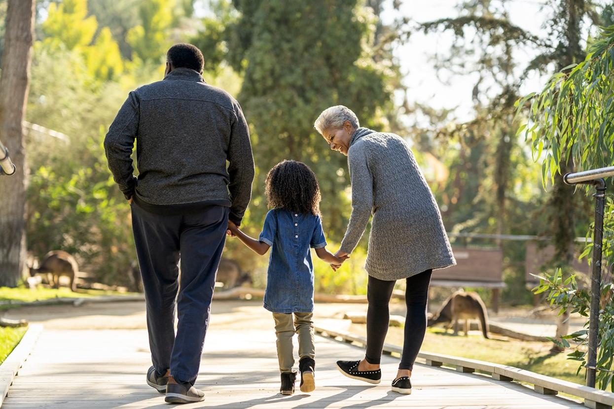 two adults walking with child