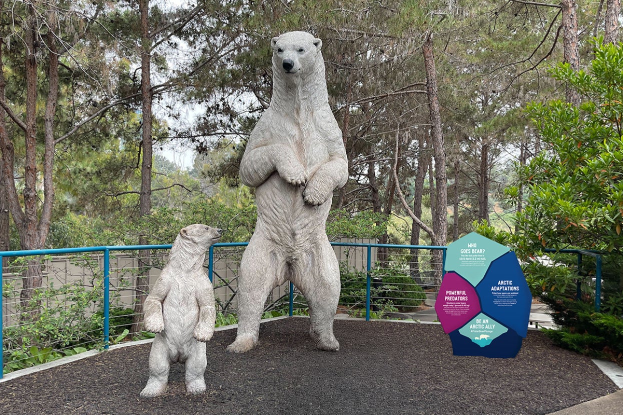 Two polar bear statues with sign