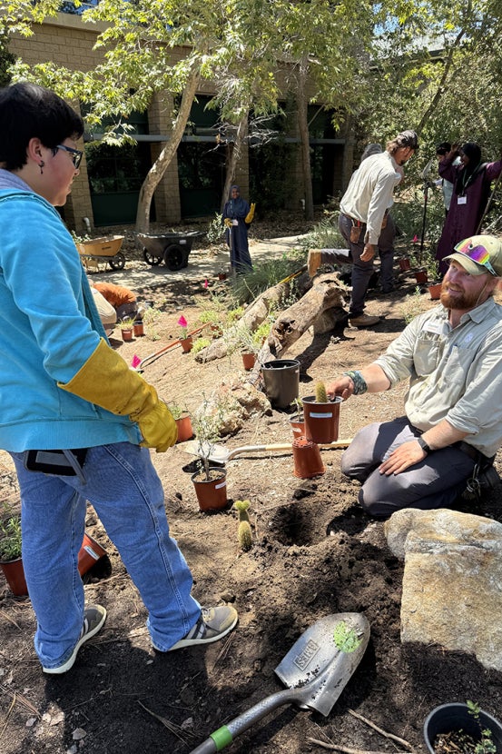 SDZWA team member shows student how to plant